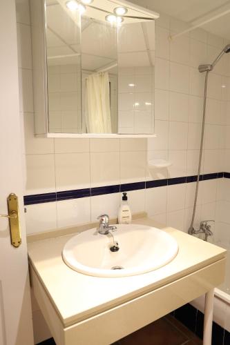 a white bathroom with a sink and a mirror at Apto en Residencial El Bosque in Chiclana de la Frontera