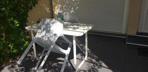 - 2 chaises blanches et une table sur la terrasse dans l'établissement Studio Provence, à Avignon