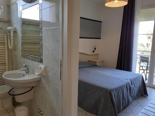 a bathroom with a bed and a sink in a room at Ariston Vacanze in Marina di Ravenna