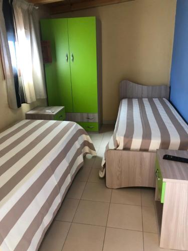 2 Betten in einem Zimmer mit grünen Schränken in der Unterkunft Casa Relax Avola in Avola