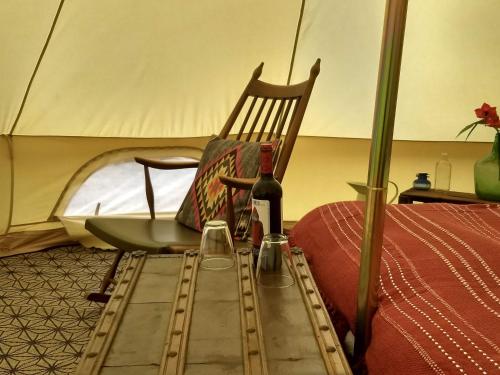 a bottle of wine and a chair in a tent at Romantic Safari tent in Tortosa