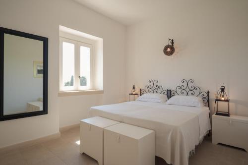オートラントにあるMasseria Montelauroの白いベッドルーム(ベッド1台、鏡付)
