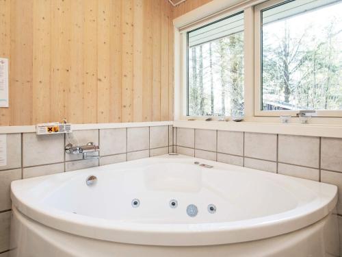 baño con una gran bañera blanca y ventana en 8 person holiday home in L kken, en Lønstrup