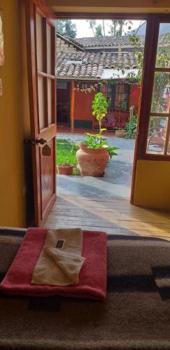 une porte ouverte avec une serviette rouge sur le pas. dans l'établissement B&B Sun Gate, à Ollantaytambo