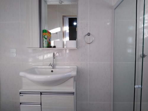 a white bathroom with a sink and a shower at Casa da Oma in Penha