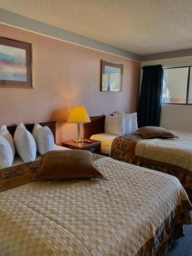 a hotel room with two beds and a lamp at Value Lodge Inn in Delta