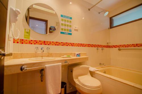 a bathroom with a toilet and a sink and a tub at Hotel Piedras Blancas - Comfenalco Antioquia in Guarne