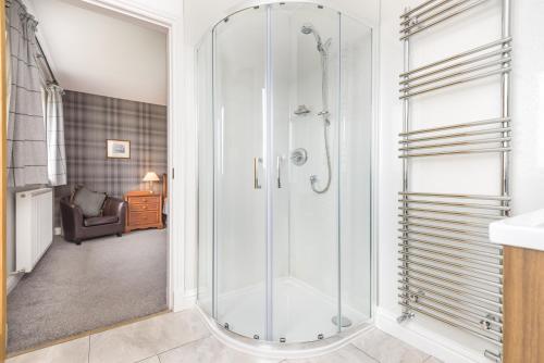 a shower with a glass door in a bathroom at Tarskavaig B&B in Radernie