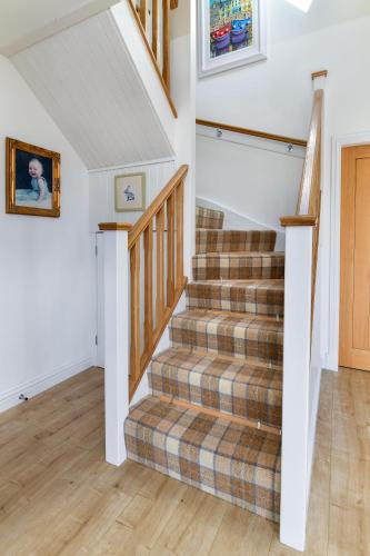a staircase in a house with a plaid carpet at Tarskavaig B&B in Radernie