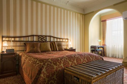 a bedroom with a bed with a bench in it at Hadley's Orient Hotel in Hobart