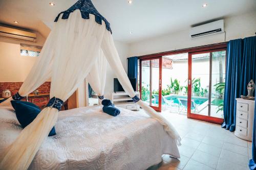 a bedroom with a bed with a mosquito net at Villa Dewi in Seminyak