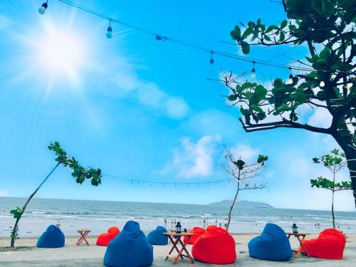 a beach with blue and red chairs and the ocean at Thien Nhan Hotel in Cửa Lô