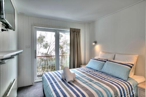 a small bedroom with a bed and a window at 10 Maisonettes in Falls Creek