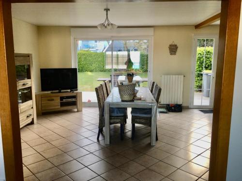 une salle à manger avec une table, des chaises et une télévision dans l'établissement la Margaret Face mer, à Équihen-Plage