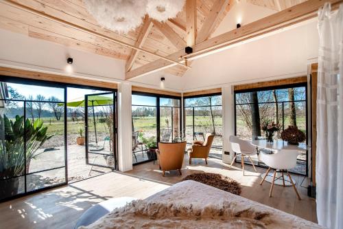 een slaapkamer met een bed en een tafel en stoelen bij Dream house Esveld in Terschuur