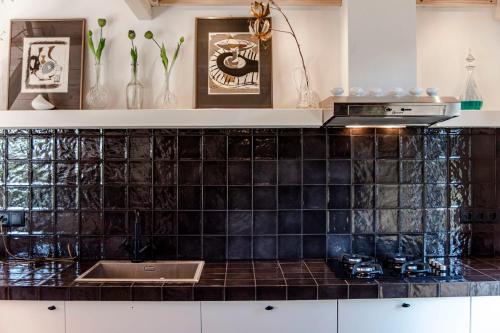 una cocina con azulejos negros en la encimera en Dream house Esveld en Terschuur