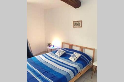 une chambre avec un lit avec des draps bleus et blancs dans l'établissement Charmante Escale au Cœur du Panier près Vieux Port, à Marseille