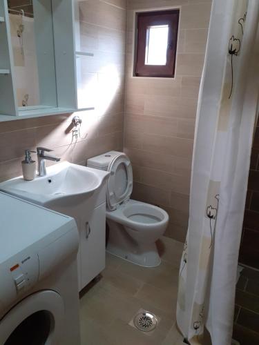 a bathroom with a white toilet and a sink at Villa Domina in Gevgelija