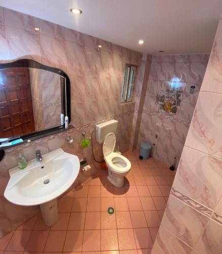 a bathroom with a sink and a toilet and a mirror at Vlora Backpackers Hostel & Bar LUNGOMARE in Vlorë