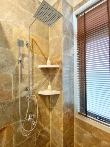 a bathroom with a shower with a glass door at Hoi An Cabbage Garden in Hoi An
