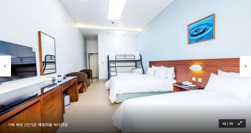 a hotel room with two beds and a television at The Stay Century Hotel in Jeju