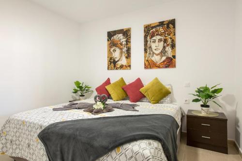 una camera da letto con un letto con tre dipinti sul muro di 8145a - Bonito Bungalow Costa Calma a Costa Calma