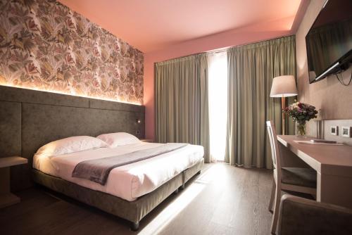 Un pat sau paturi într-o cameră la Hotel Ristorante Ala d'Oro