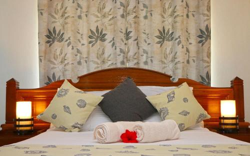 a bed with two towels and pillows on it at Saria Self Catering in Anse Possession