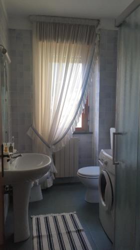 uma casa de banho com um lavatório branco e um WC. em Al Numero 4 em Levanto