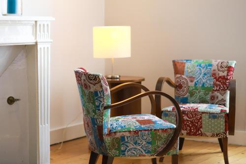 a room with two chairs and a table with a lamp at DEMEURE DES CORDELIERS avec parking privé in Blois