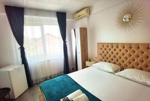 a bedroom with a bed and a large window at Casa Laura in Mangalia