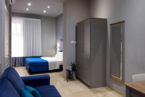 a hotel room with a bed and a blue couch at ZIBIBBO SUITES & ROOMS - Aparthotel in Centro Storico a Trapani in Trapani