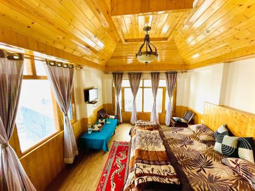 a bedroom with two beds and a wooden ceiling at La Voglia-Old Manali in Manāli