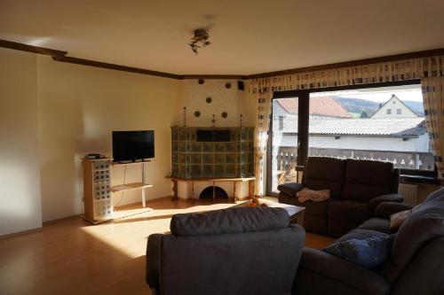 a living room with a couch and a television at Ferienhof Spiegel in Hilders