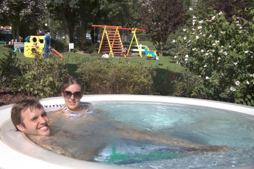 a man and a woman in a hot tub at Garden Hotel Bellariva in Molveno