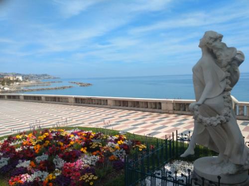 a statue of a woman standing next to a flower garden at Hotel Morandi in Sanremo
