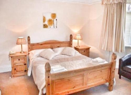 um quarto com uma grande cama de madeira e 2 mesas de cabeceira em Westbourne Lodge em Birmingham