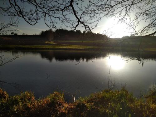 a lake with the sun reflecting on the water at Ferienwohnung am Marktplatz in Sparneck
