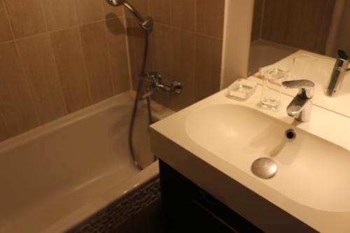 une salle de bain avec un lavabo, une baignoire et une douche dans l'établissement location saisonnière belle vue sur mer, à Six-Fours-les-Plages