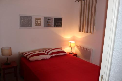 - une chambre avec un lit rouge et 2 oreillers dans l'établissement location saisonnière belle vue sur mer, à Six-Fours-les-Plages
