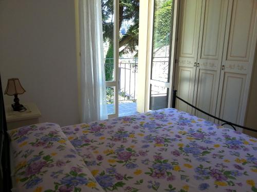una camera da letto con un letto con un piumone floreale e una finestra di Casakatty a Bellagio