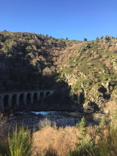 a bridge over a river on a hill at Le Marconnès in Saint-Arcons-de-Barges