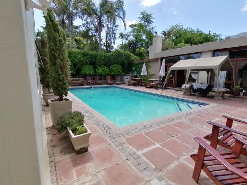 a swimming pool in front of a house at Aanhuizen Guest House in Swellendam