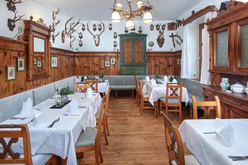 a restaurant with white tables and chairs and a chandelier at Gasthof Post St. Martin am Tgb. in Sankt Martin am Tennengebirge