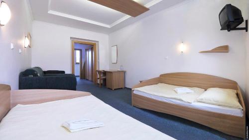 um quarto de hotel com duas camas e uma televisão em Penzión DRUŽBA Bojnice em Bojnice