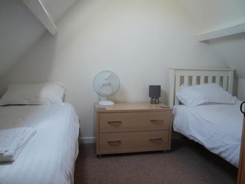 a bedroom with two beds and a night stand with a fan at Red Lion in Exeter