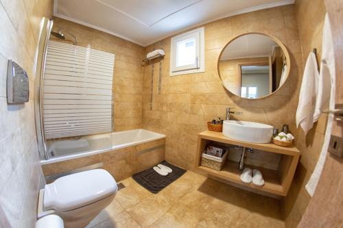 a bathroom with a toilet and a sink and a mirror at Kassiopi Luxury Suites in Kassiopi