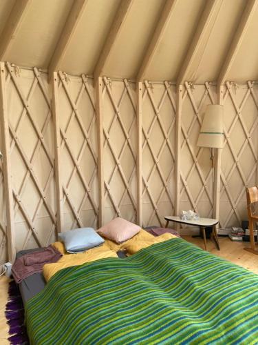 a bedroom with a bed in a tent at Black Yurt Chromiec in Stara Kamienica