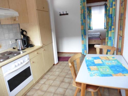 cocina con mesa, fogones, mesa y sillas en Appartement Rhönzimmer, en Findlos