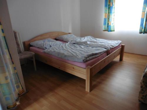 FindlosにあるAppartement Rhönzimmerのウッドフロアの客室の小さなベッド1台分です。
